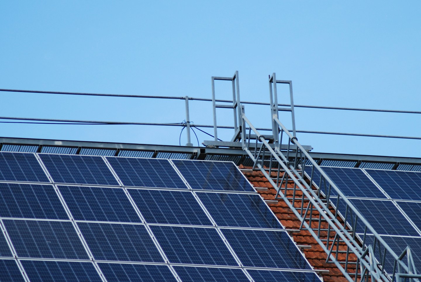 Dunkelblaue Solarmodule auf einem Ziegeldach.
