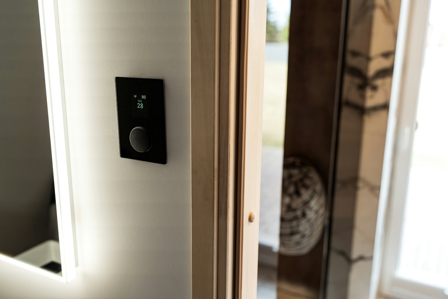 Smart-Home-Bedienfeld an grauer Wand mit Temperaturanzeige.