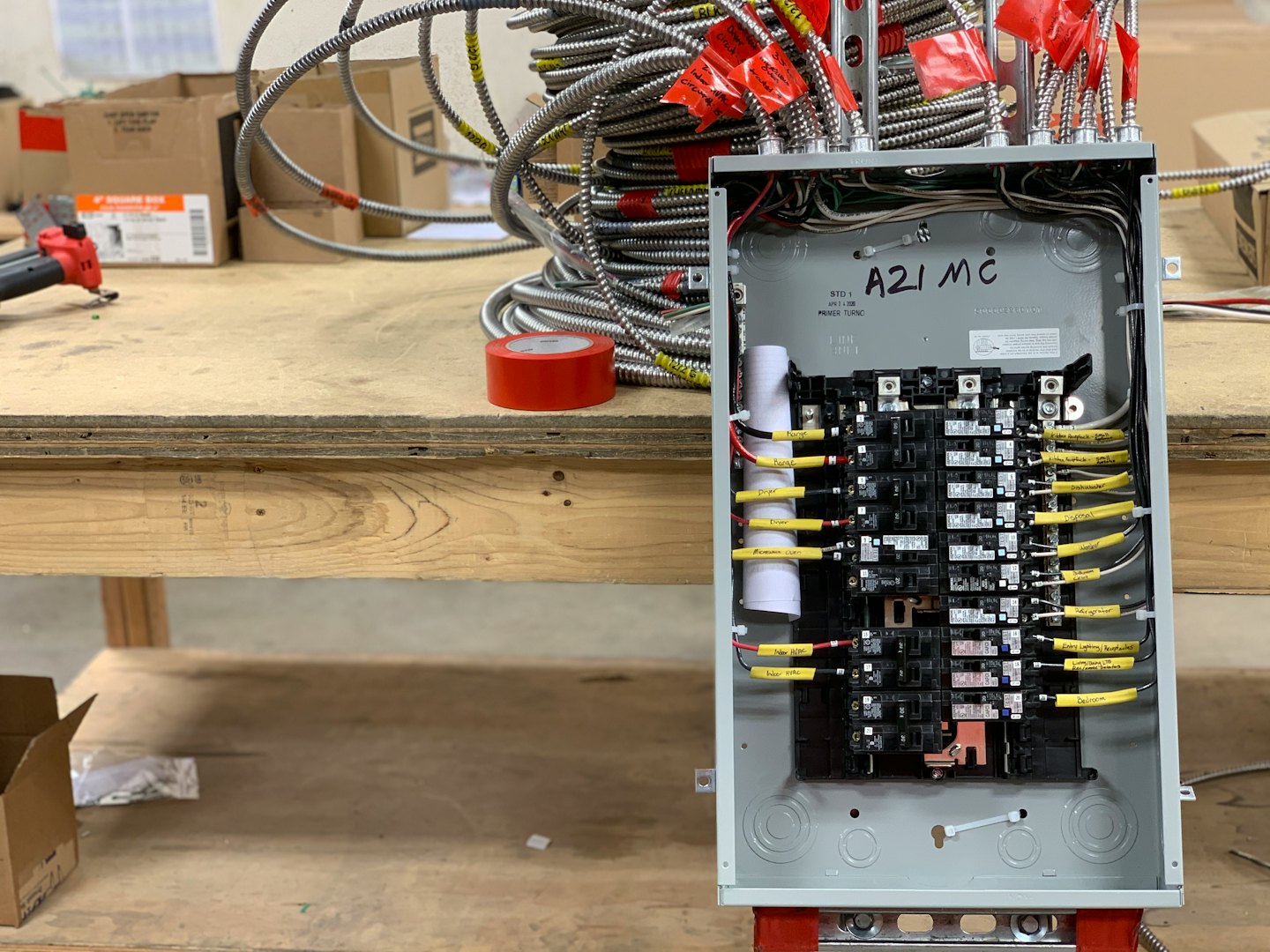Ein Elektropaneel wird auf einer Werkbank mit Leitungen verdrahtet.