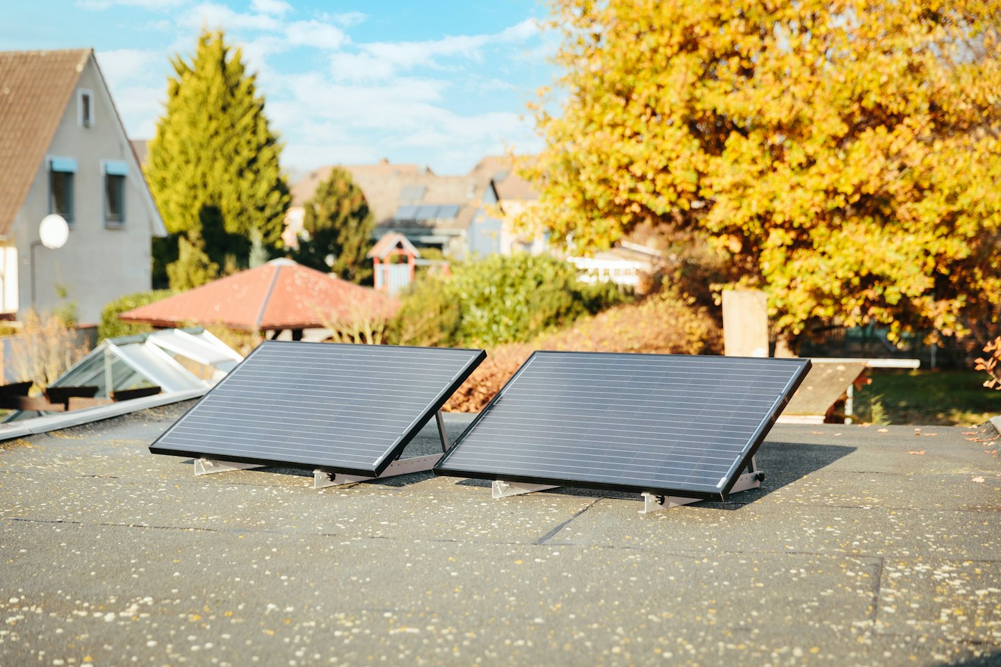 Zwei Solarpaneele auf einem Dach unter strahlendem Sonnenschein.
